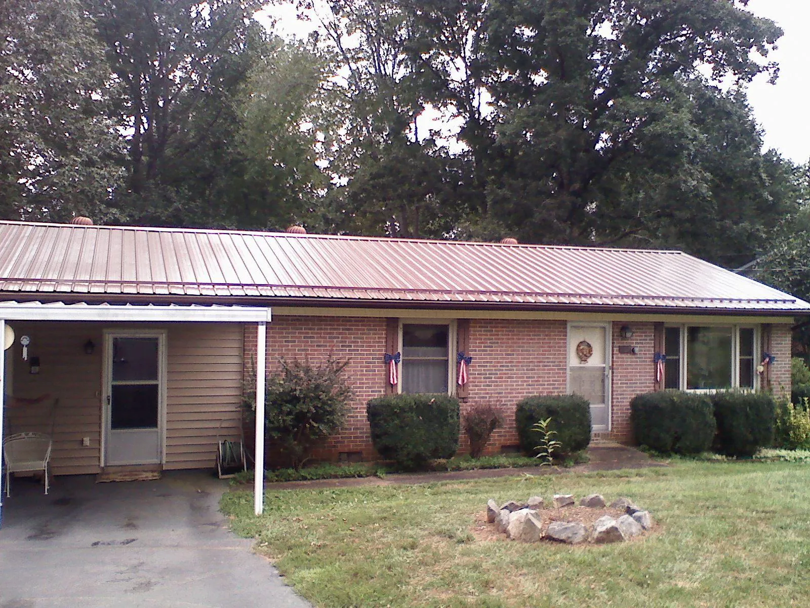 Bronze metal roof and carport on a brick ranch home — Roof Repair work by our crew in South Bend